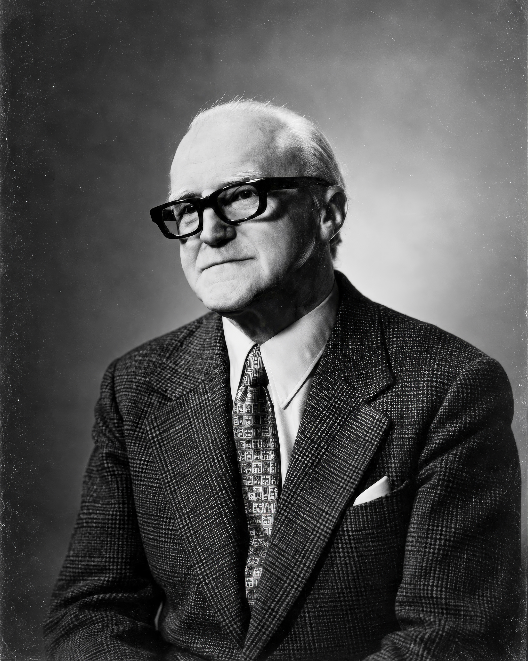 Black-and-white portrait of Eugen Suchoň wearing a suit and glasses